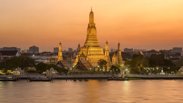 Wat Arun temple on the Chao Phraya River at sunset