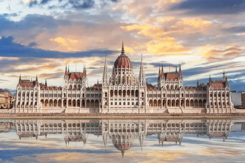 The Hungarian Parliament mirrored in the Danube at sunset in Budapest