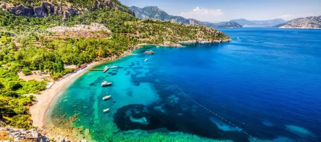 Turquoise Coast bay near Dalaman with a beach, boats and pine-clad hills