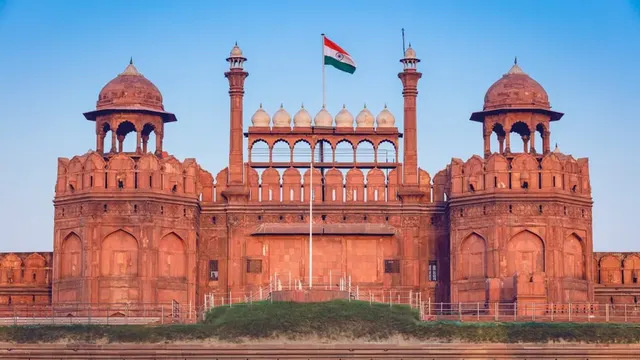 Red Fort's red sandstone Lahori Gate flying the Indian flag at sunrise, Delhi