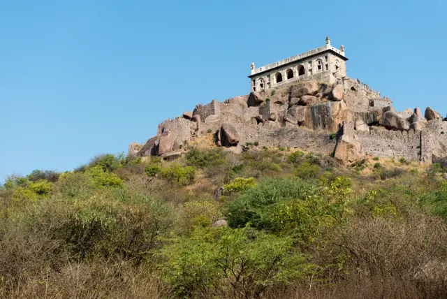 Golconda Fort's hilltop pavilion and stone ramparts above scrubland, Hyderabad