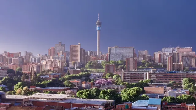 Hillbrow Tower above the Johannesburg skyline and jacaranda trees