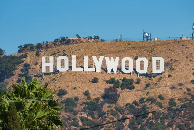 The Hollywood sign on a hillside above Los Angeles, palms below
