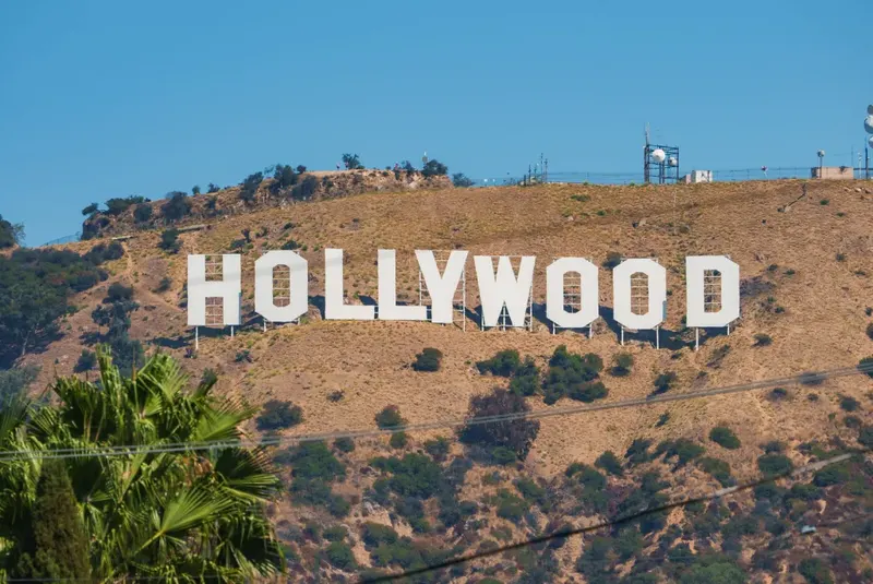 The Hollywood sign on a hillside above Los Angeles, palms below