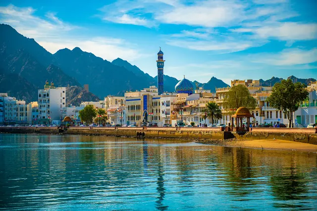 Muscat's harbourfront houses beneath rugged mountains