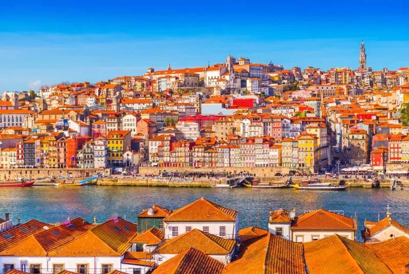 Colourful Ribeira houses above the Douro with the Clerigos Tower, Porto