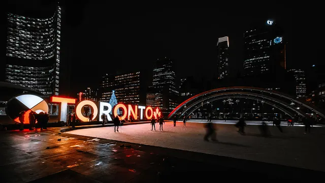 The Toronto sign glowing at Nathan Phillips Square at night