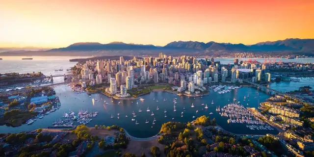 Downtown Vancouver skyline and the North Shore mountains above Coal Harbour at sunset