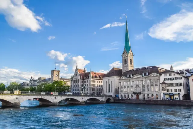 Fraumunster church's green spire beside the Limmat river in Zurich's old town